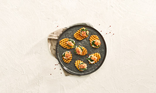 Super crispy seasoned patatas fritas cortadas en gofre con queso de cabra, espinacas y salmón