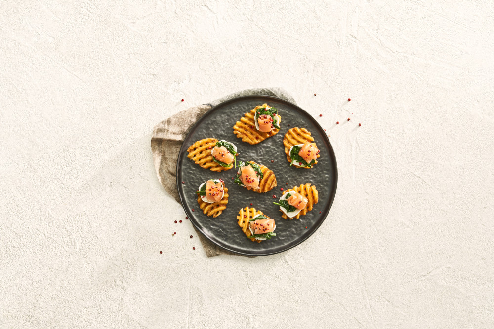 Super crispy seasoned waffle cut fries avec du fromage de chèvre, des épinards et du saumon.