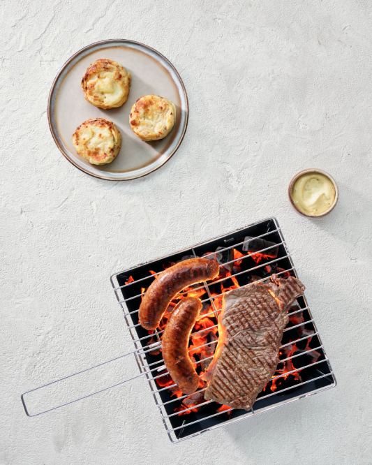 Potato gratin with truffle flavour and mushroom with sausage and steak on the BBQ