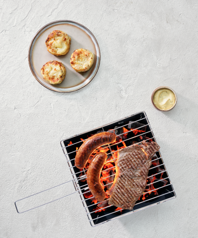 Potato gratin with truffle flavour and mushroom with sausage and steak on the BBQ