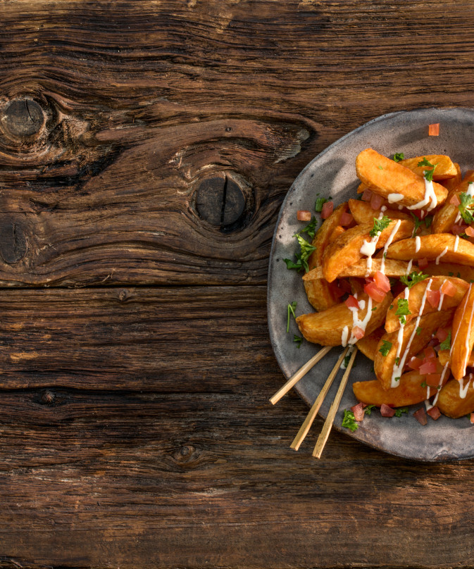 Crispy seasoned wedges with sour cream and tomatoes